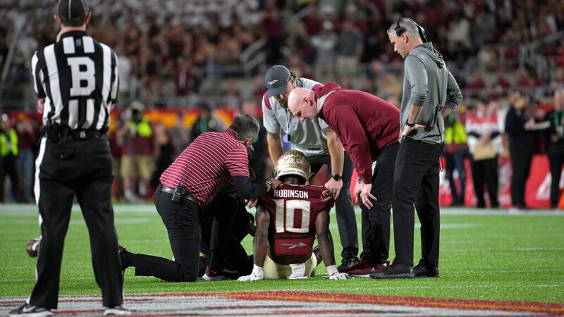 Florida State defensive back Jammie Robinson (10) is helped after getting injured on a play...