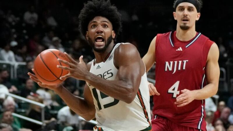 Miami forward Norchad Omier powers past New Jersey Institute of Technology guard Adam Hess (4)...
