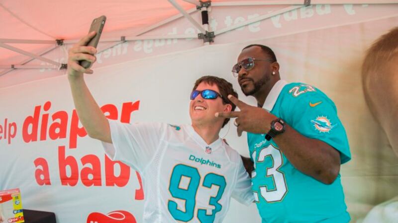 IMAGE DISTRIBUTED FOR HUGGIES - Fan poses with former Miami Dolphins cornerback Patrick...
