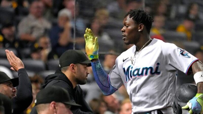 Miami Marlins' Jazz Chisholm Jr., right, returns to the dugout after hitting a solo home run...