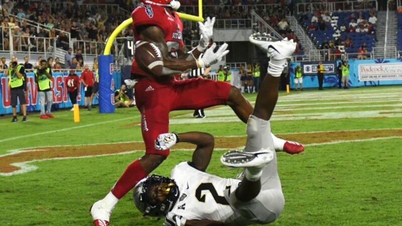 Florida Atlantic safety Zyon Gilbert, top, defends against UCF running back Otis Anderson (2)...