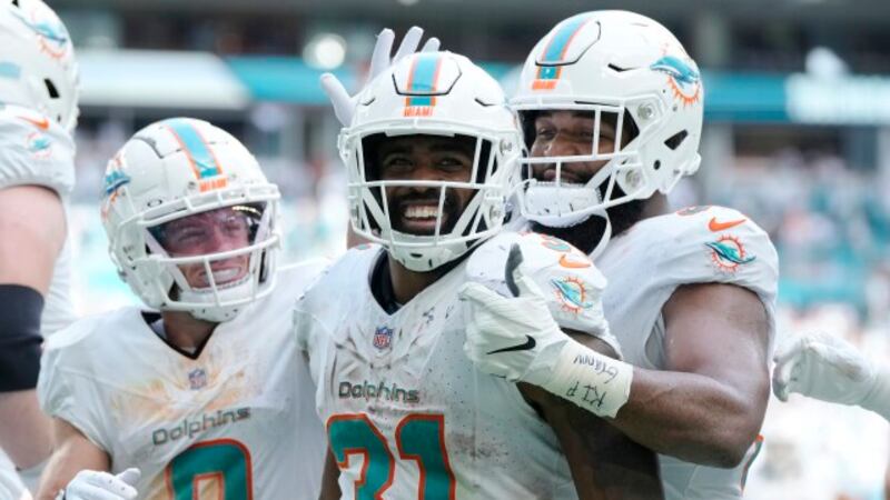 Miami Dolphins running back Raheem Mostert (31) is congratulated by wide receiver Braxton...