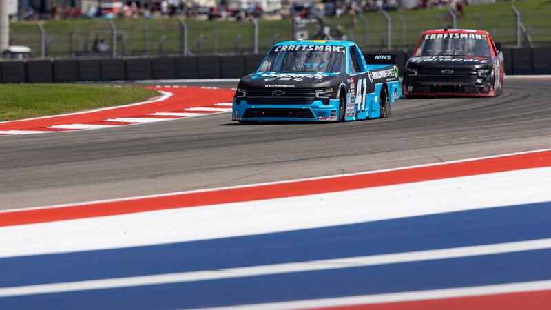 Ross Chastain, left, and Kyle Busch steer their trucks through Turn 17 during a NASCAR Truck...