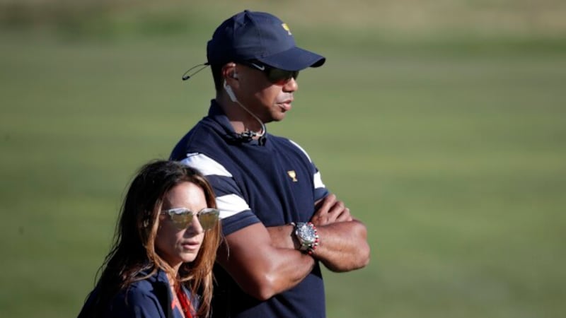 Tiger Woods, top, assistant United States team captain, and his associate Erica Herman, watch...