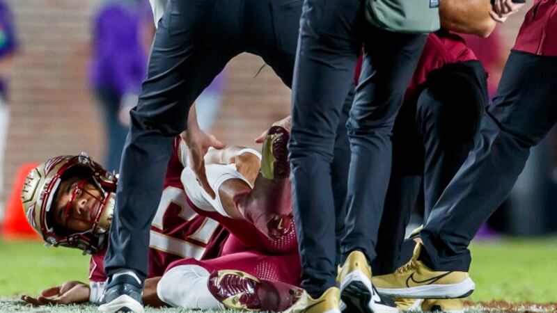 Florida State quarterback Jordan Travis receives attention on the field after being injured...