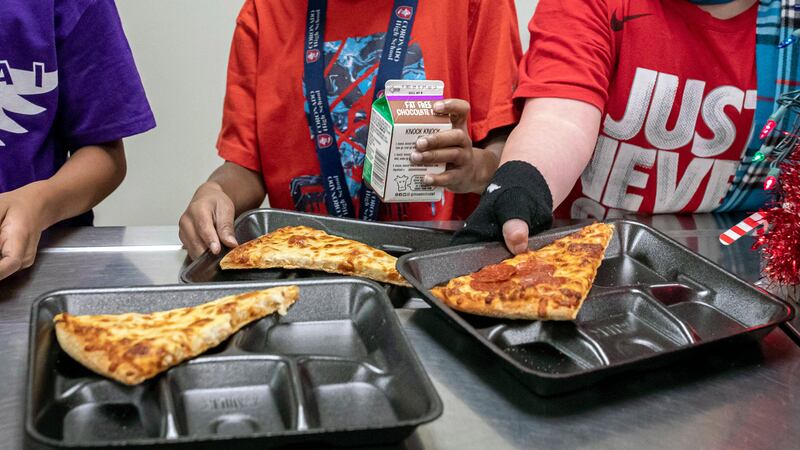 FILE - Second-grade students select their meals during lunch break in the cafeteria, Dec. 12,...