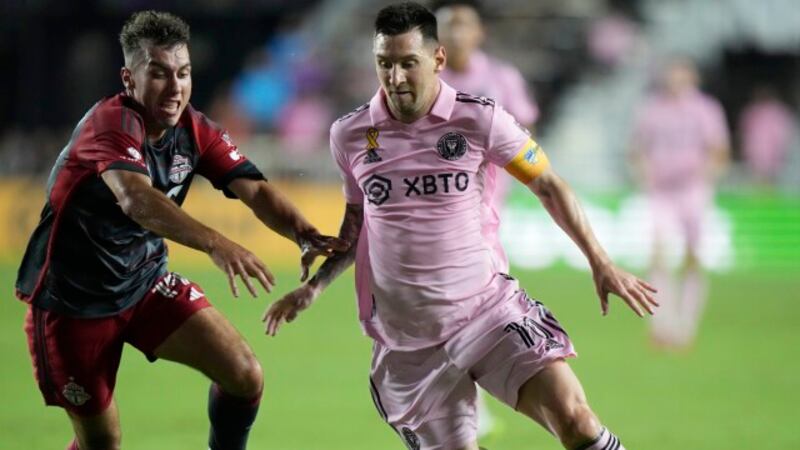 Inter Miami forward Lionel Messi, right, takes the ball past Toronto FC defender Kobe Franklin...