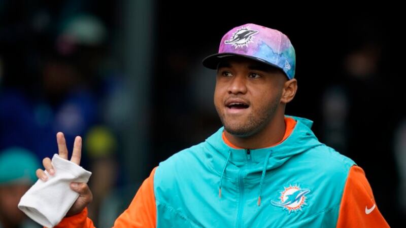 Miami Dolphins quarterback Tua Tagovailoa (1) walks onto the field, not dressed to play, ahead...