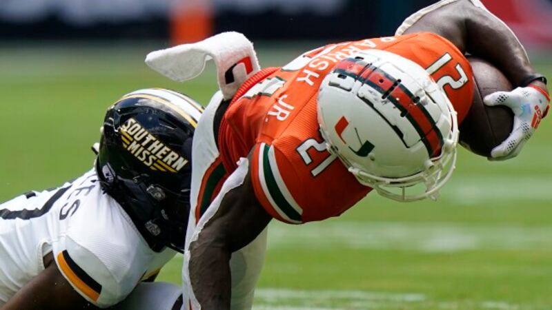 Southern Miss defensive back Brendan Toles takes down Miami running back Henry Parrish Jr....